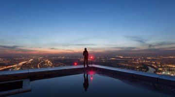 Image of man standing overlooking the skyline, represents 1Up's commitment to visionary thinking and unafraid of challenges