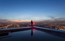 Image of man standing overlooking the skyline, represents 1Up's commitment to visionary thinking and unafraid of challenges