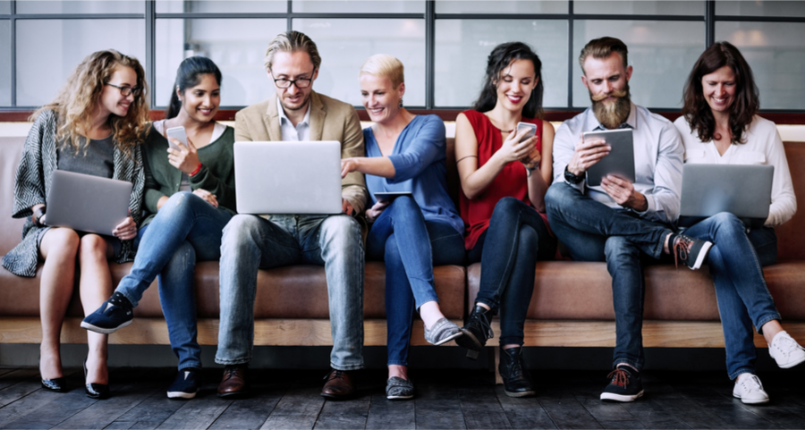 Image of a group of practitioners using social media across multiple devices in a strategy session, focussed on understanding the customers